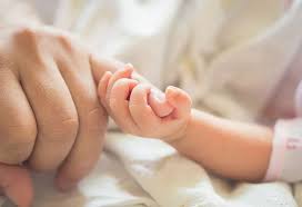 Pediatrician testing baby grasp reflex