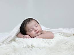 Baby lying on soft blanket in natural daylight
