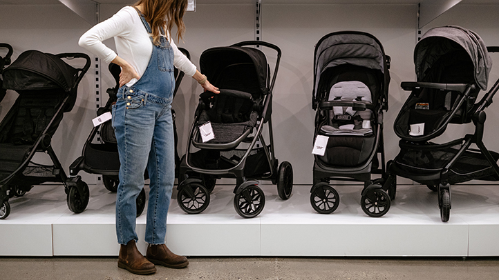 Parent evaluating baby stroller options in store