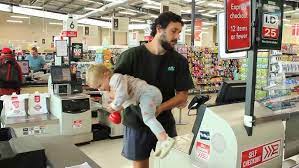 Confused dad in baby aisle during solo parenting adventure