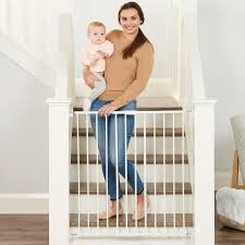 Parent installing baby gate on stairway