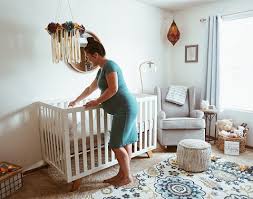Expecting mother setting up a crib in a nursery