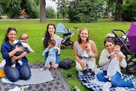 Mothers making friends and sharing parenting advice in a local park.