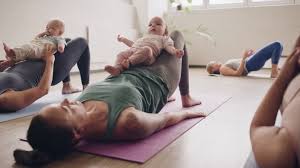 Mothers and babies practicing yoga together in a calm group setting